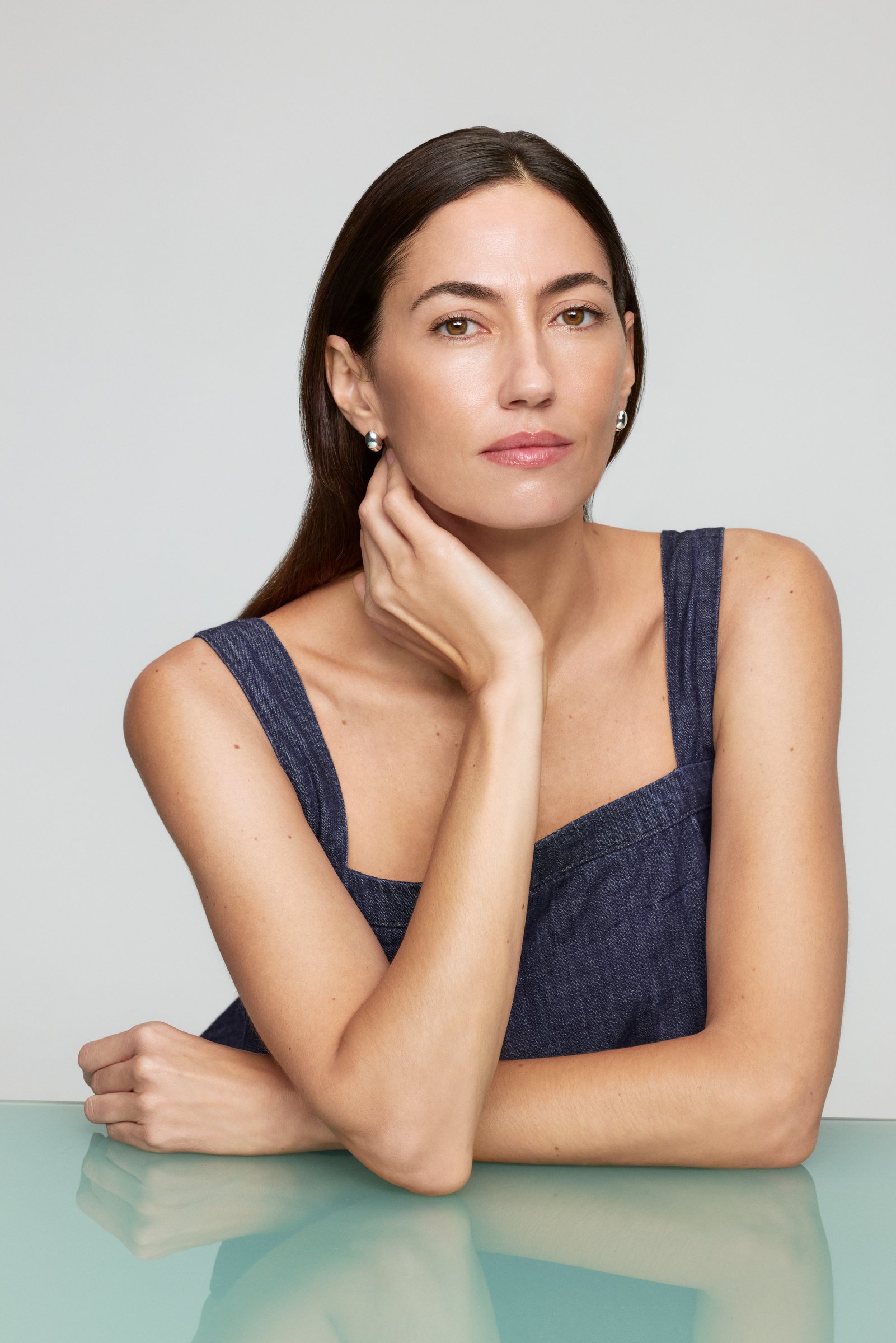 Paloma López con vestido azul, apoyada sobre una mesa
